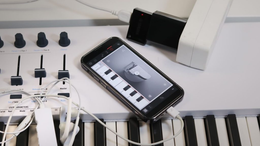 The Yamaha UD-BT01 connects to the instrument via USB and is powered by a USB charger. The charger supplies power to both the wireless MIDI adapter and the connected MIDI keyboard—in this case, an Arturia KeyLab 88 MkII.
